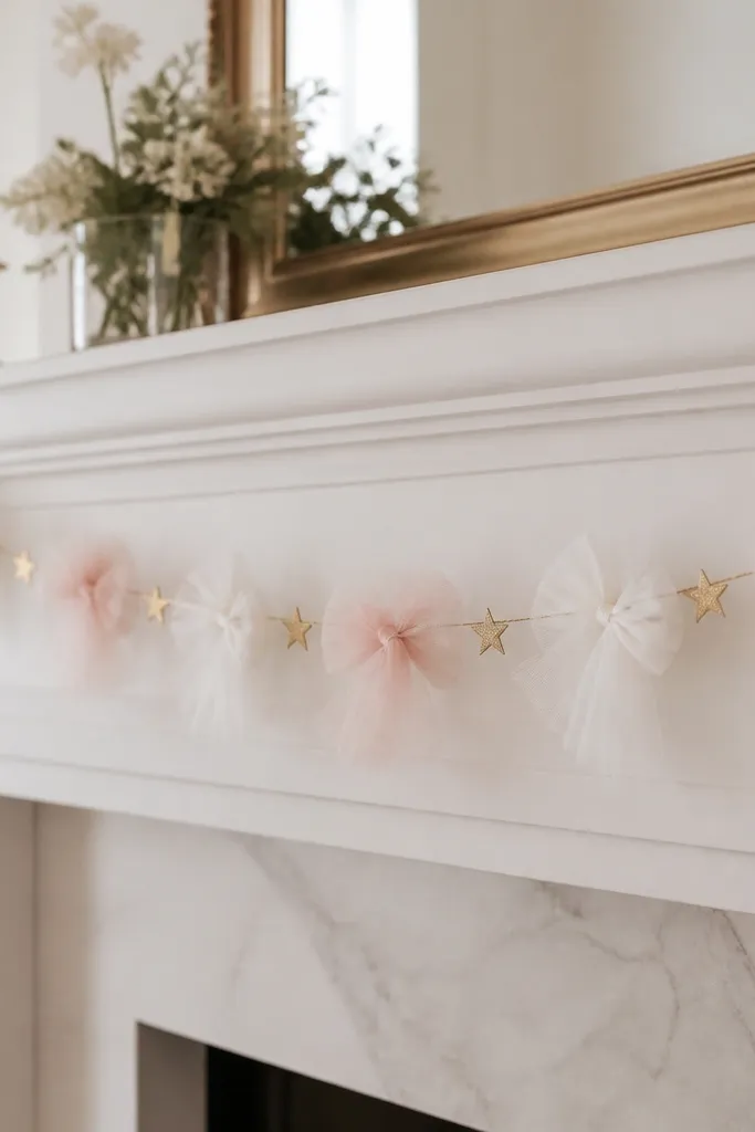 A garland strung along a mantle with small tulle bows every 6 inches. The bows alternate white and blush, and there are tiny gold paper star accents mixed in.