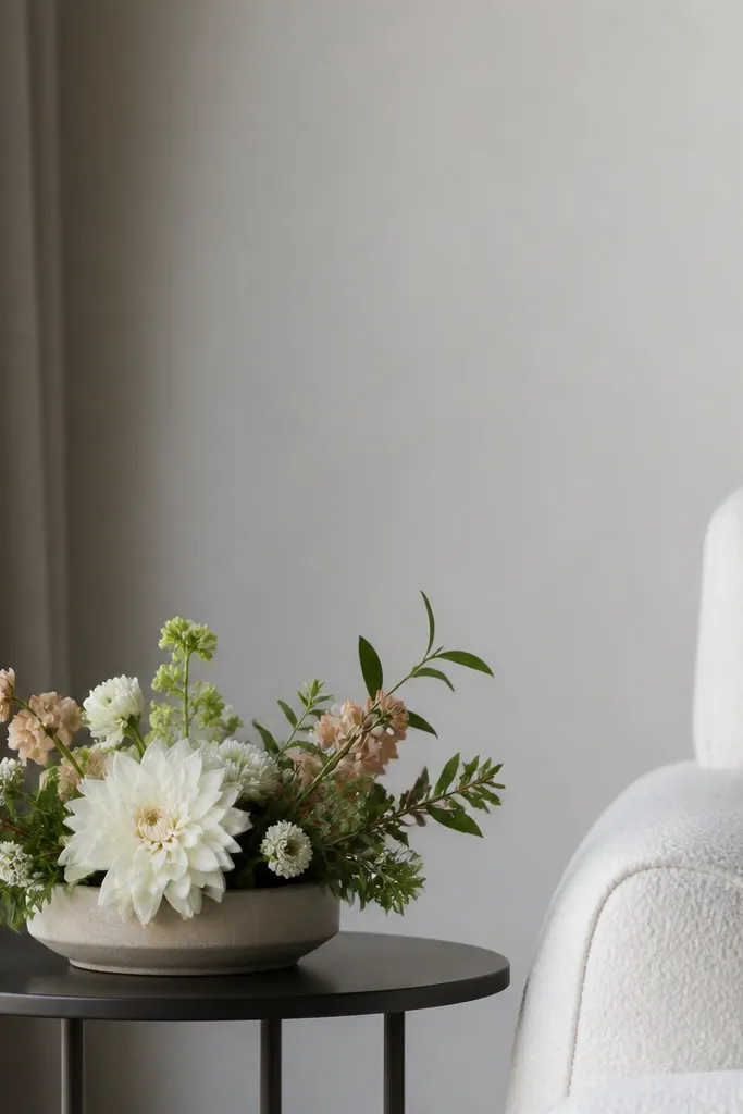 A stage side table with a low floral arrangement in a wide base. The flowers sit below the camera sightline, and the arrangement has clear negative space around it.